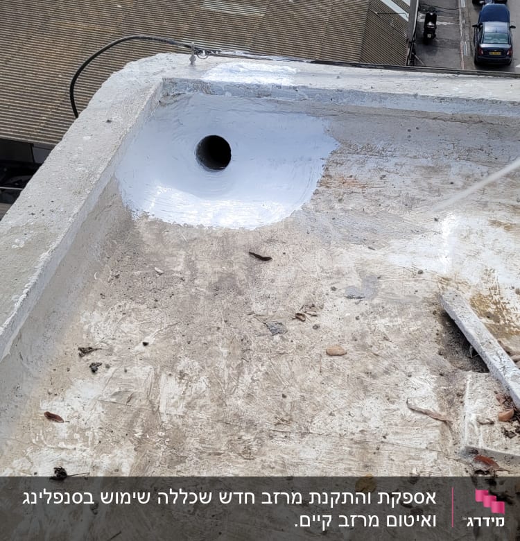 פתח ניקוז על גג עם ציפוי לבן מסביב